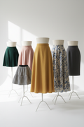 Stylish women's skirts in various lengths and colors on a white background